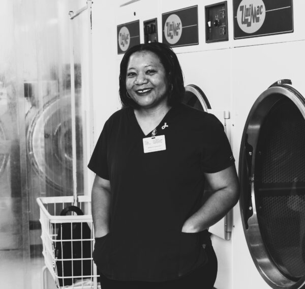Laundry aide smiling while working in a nursing facility.